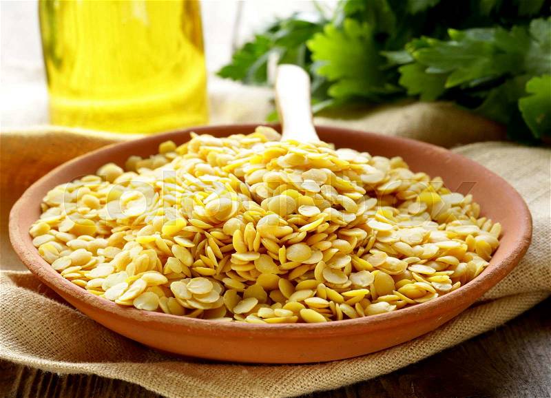 Yellow lentils in a bowl on the table, stock photo