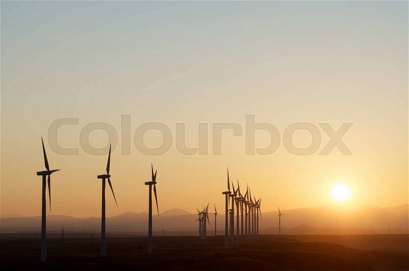 Aligned windmills for renowable electric production at sunset, Pozuelo de Aragon, Zaragoza, Aragon, Spain, stock photo