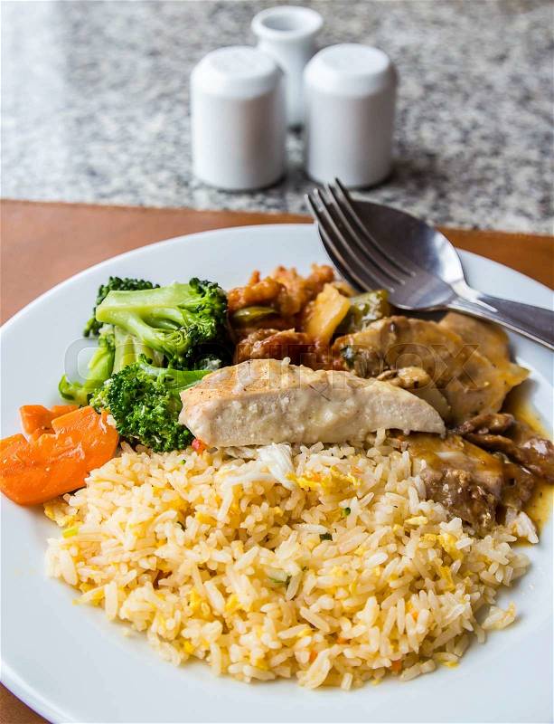 Fried rice topped with chicken and pork on the table, stock photo