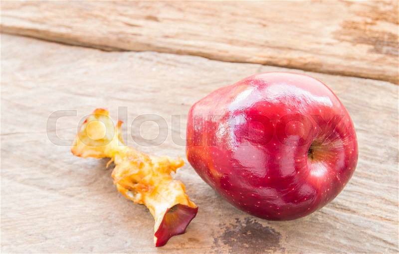 Red apple and apple core on a wooden background, stock photo