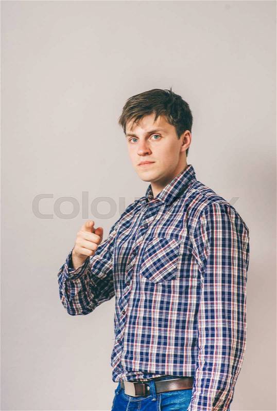 I choose you! Handsome young man in shirt looking at camera and pointing you, stock photo