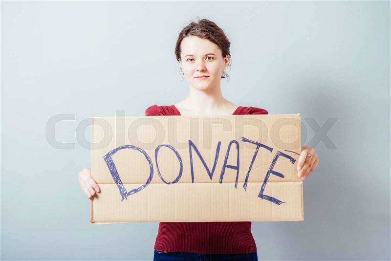 A woman with a cardboard sign on the donate, stock photo