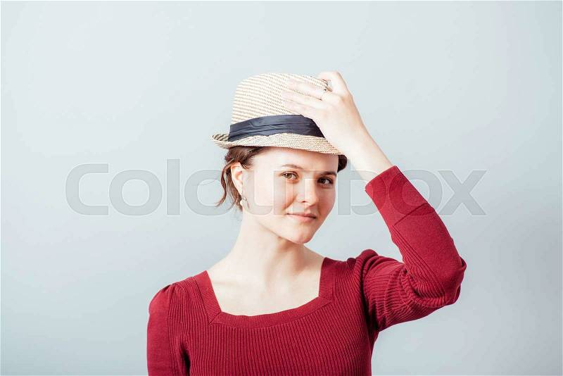 Young woman take off her hat, stock photo