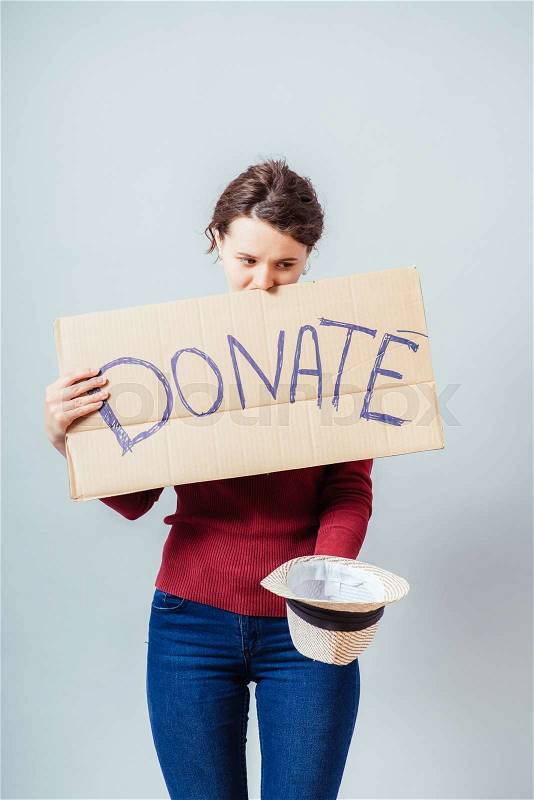 A woman with a cardboard sign on the donate, stock photo