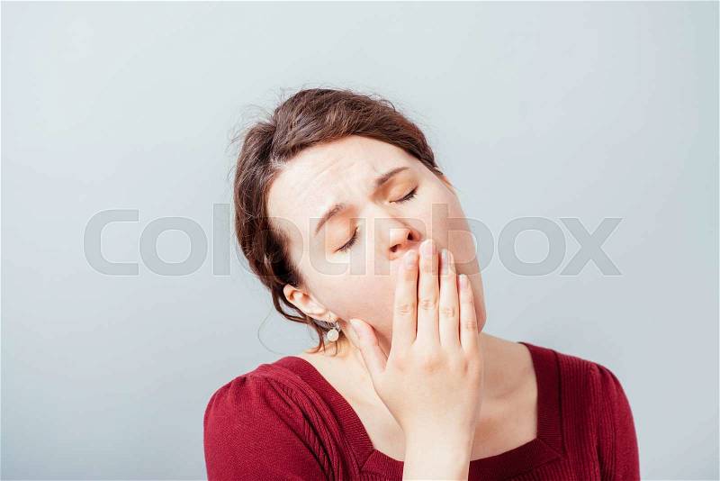 Sleepy young woman yawning, stock photo