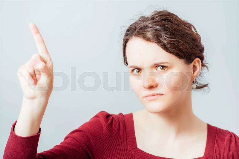 Beautiful brunette girl points finger to somesing, stock photo