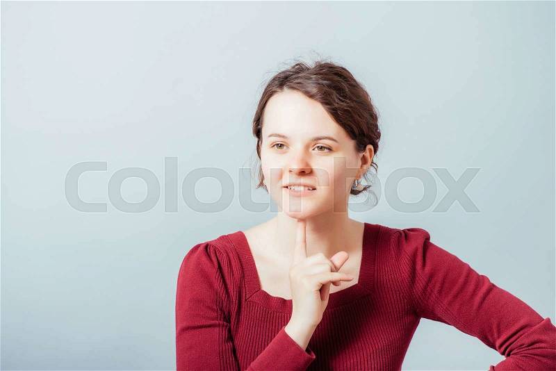 Thinking woman with finger on chin, stock photo