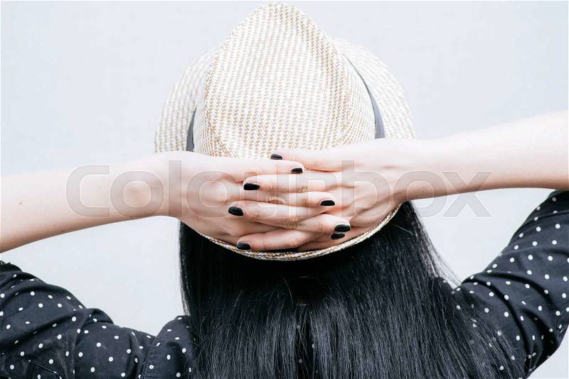 Girl in hat put hands behind her head, stock photo