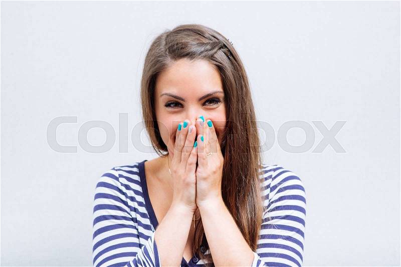 Happy woman laughing covering her mouth with a hands, stock photo