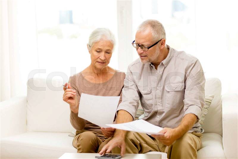 Family, business, savings, age and people concept - smiling senior couple with papers and calculator at home, stock photo