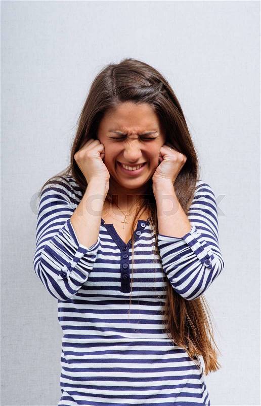 Girl covers ears with her hands, stock photo