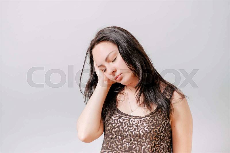 A woman wants to sleep. Gray background, stock photo