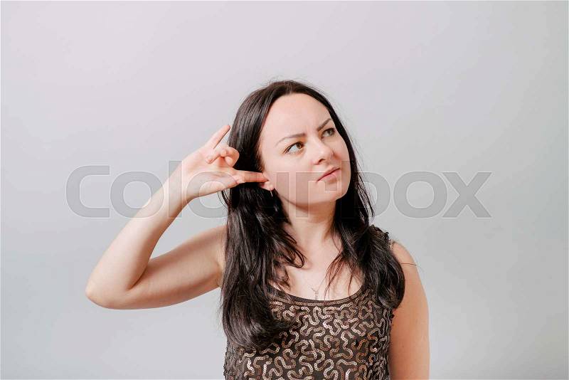 Do not want to hear anything. Young woman closing ears with hands, isolated on white, stock photo