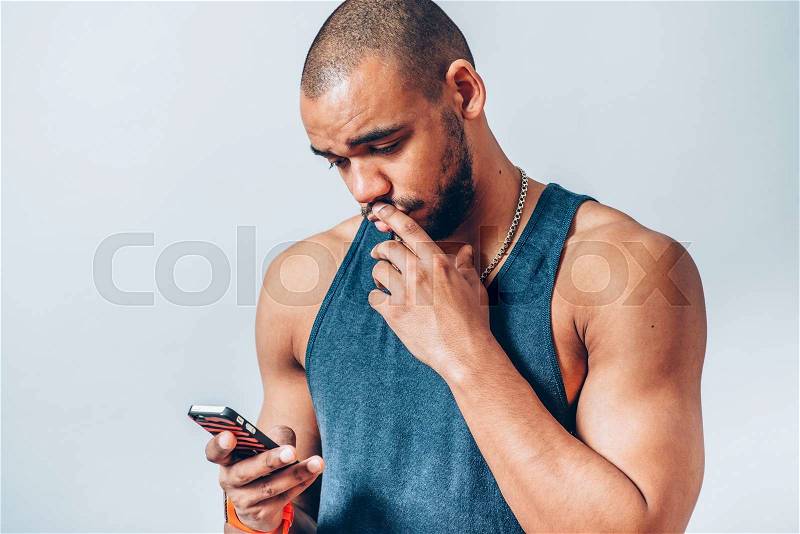 Dark-skinned man holding a cell, holding paper, stock photo