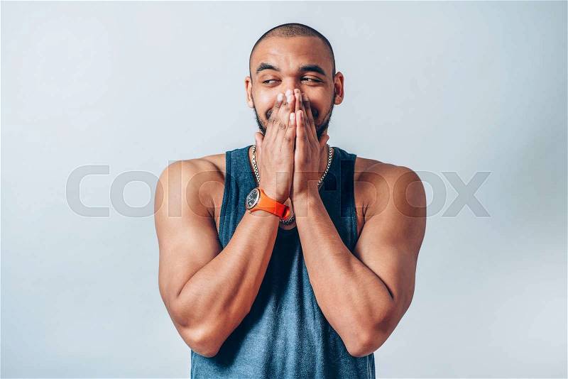 Black man laughs and covers her mouth, stock photo