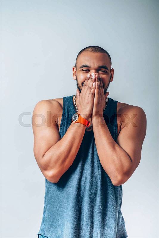 Black man laughs and covers her mouth, stock photo