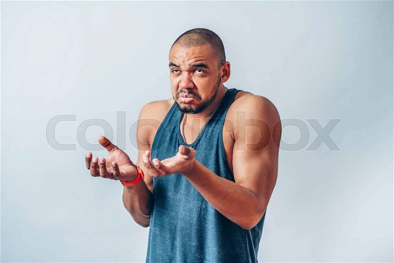 A dark-skinned man holding something invisible in his hands, stock photo