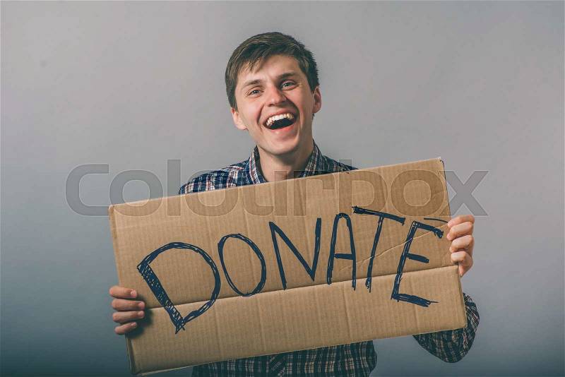 A man with a cardboard sign on the donate, stock photo