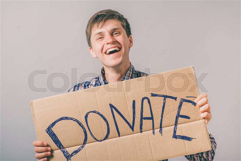 A man with a cardboard sign on the donate, stock photo
