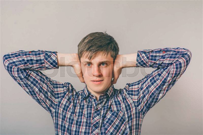 Man covers his ears with his hands, stock photo