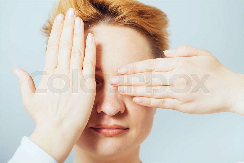 Girl closes eyes with her hands, stock photo