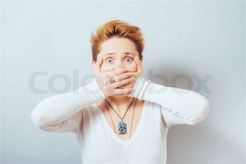 Woman covers her mouth with her hands, short hair, stock photo