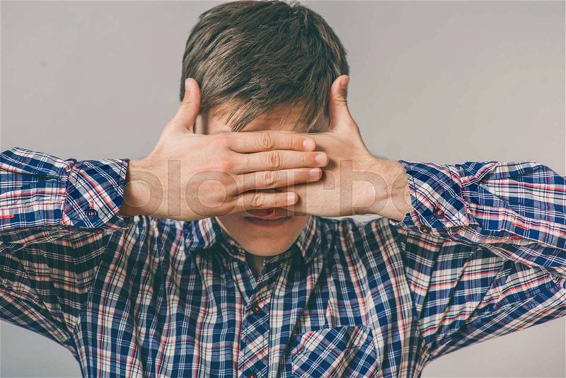 Man covering your eyes with hands, stock photo