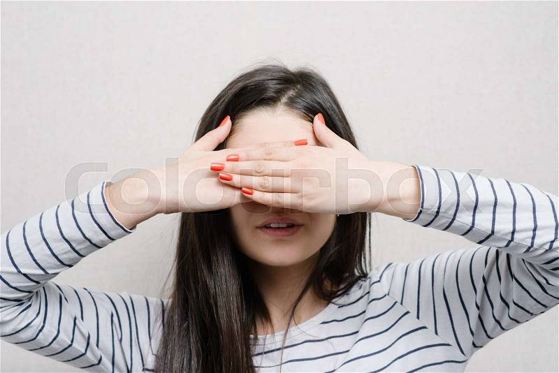 Woman covering her eyes, stock photo