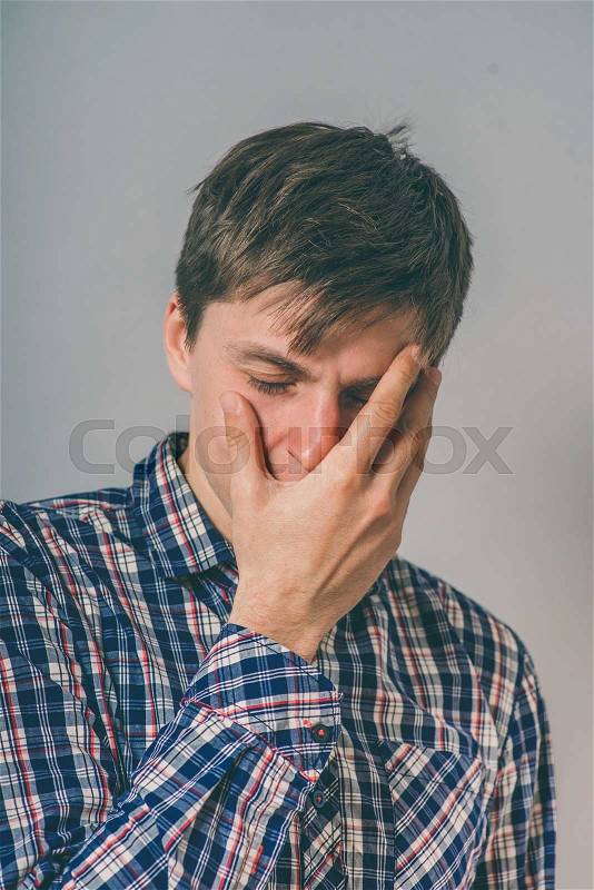 Young handsome afraid man covering his face, stock photo