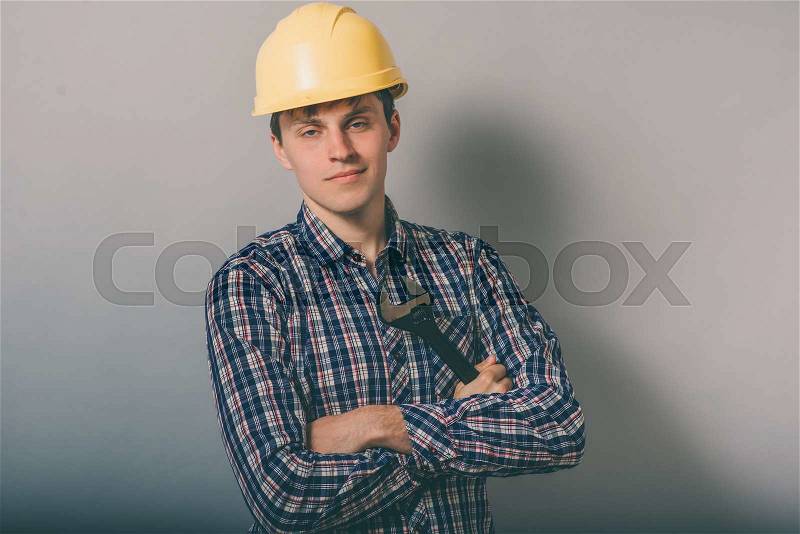 A man with a helmet with a wrench, stock photo