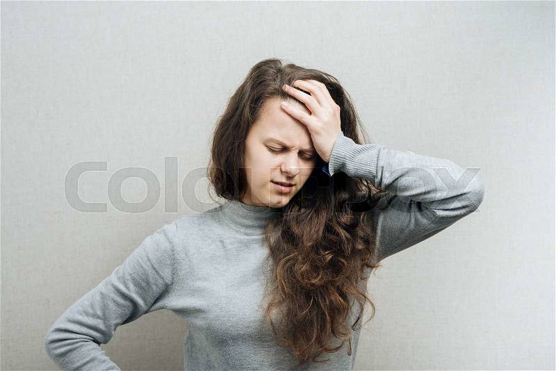 Woman headache or pressure. On a gray background, stock photo