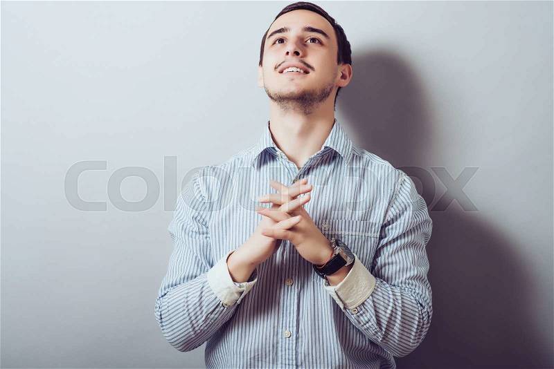 Closeup portrait of young man, praying looking up hoping for best asking for forgiveness, miracle isolated white background. Human emotions, facial expressions, feelings, reaction, stock photo