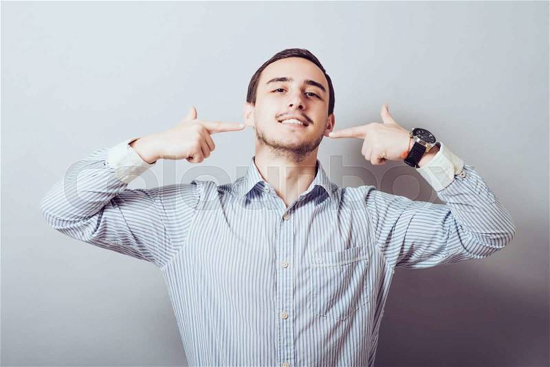 Portrait of handsome man pointing at his healthy smile or teeth , stock photo