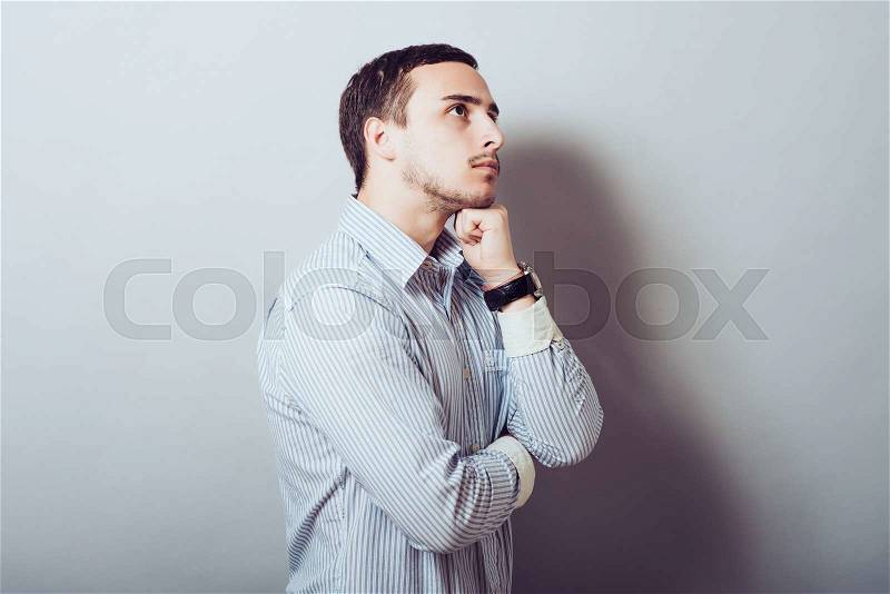 Side view of a pensive man looking away from the camera, stock photo