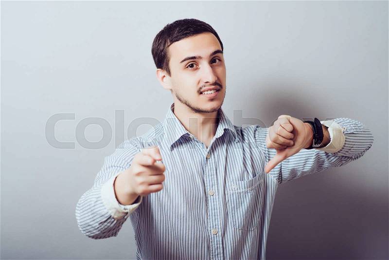 You suck. Portrait unhappy, angry, mad, executive man, annoyed, giving showing thumb down gesture pointing at you finger looking with negative facial expression disapproval , stock photo