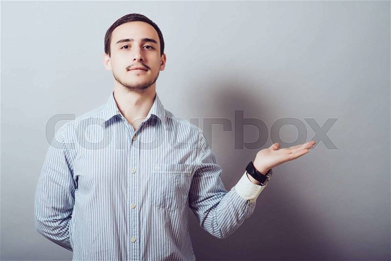 Young man showing something with his hand, stock photo