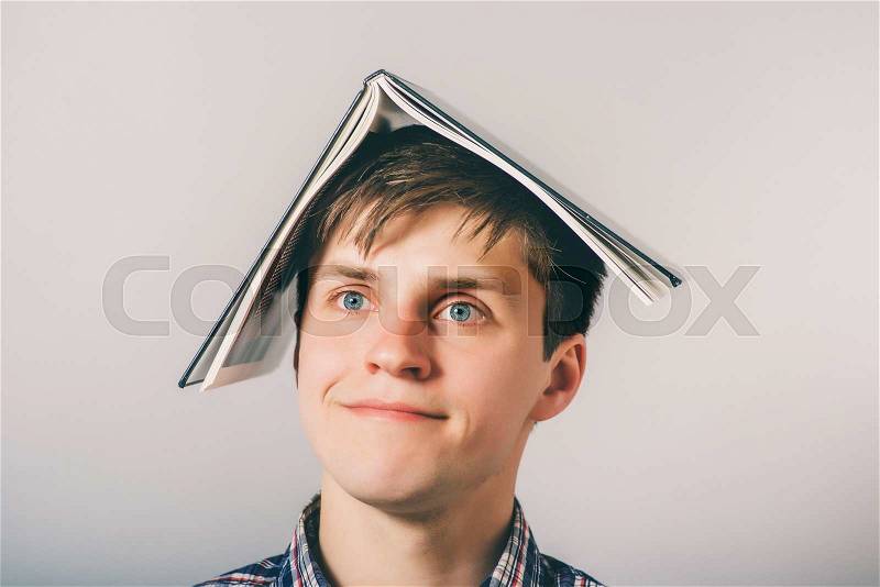 Man holding an open book on his head, stock photo