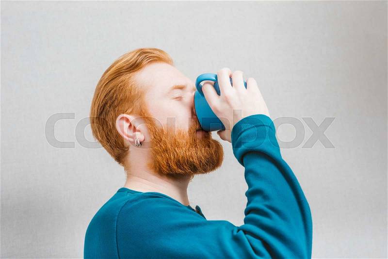 Portrait of handsome young man drink a cup tea, coffe, milk or other, stock photo