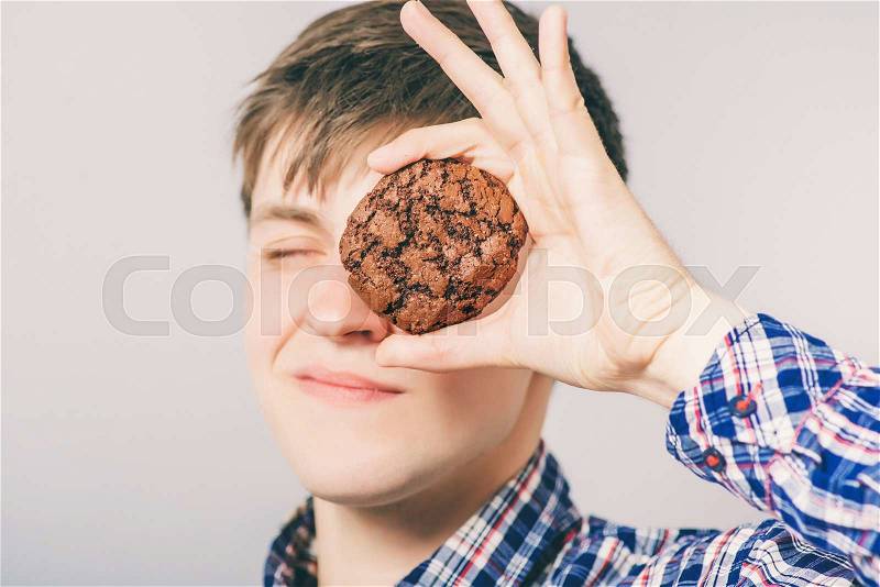 Young man eating cookies or biscuits, stock photo
