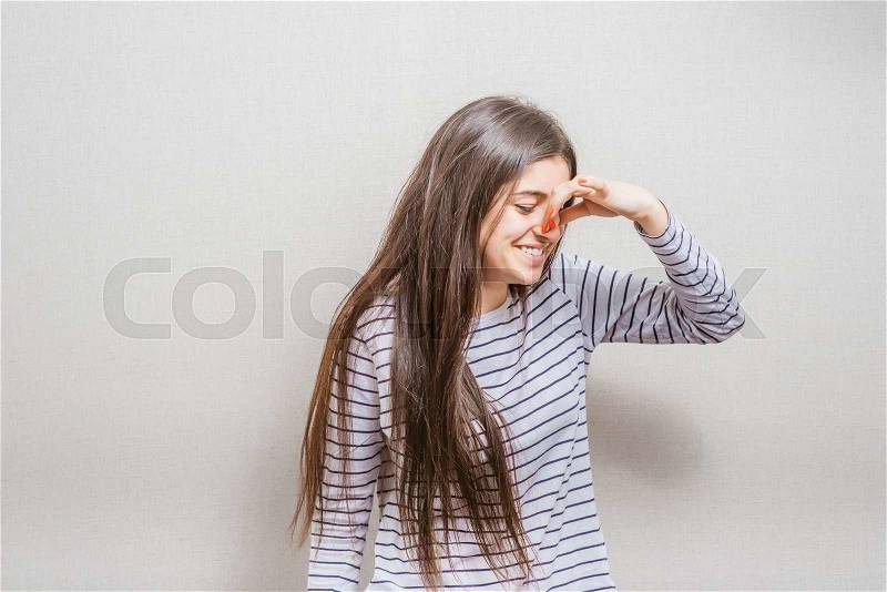 Female gesture smells bad, closed nose. isolated on gray background, stock photo