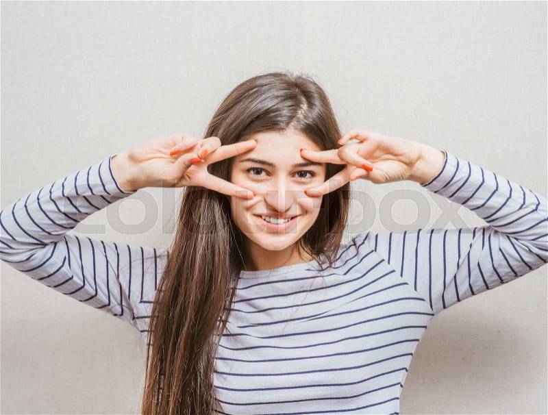 Portrait of a girl giving victory sign, stock photo