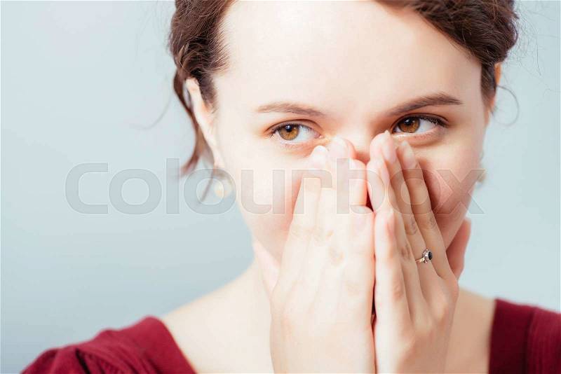 The woman smiles, covers a mouth with a palm, stock photo