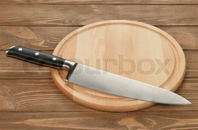 Kitchen knife and cutting board on a brown background, stock photo