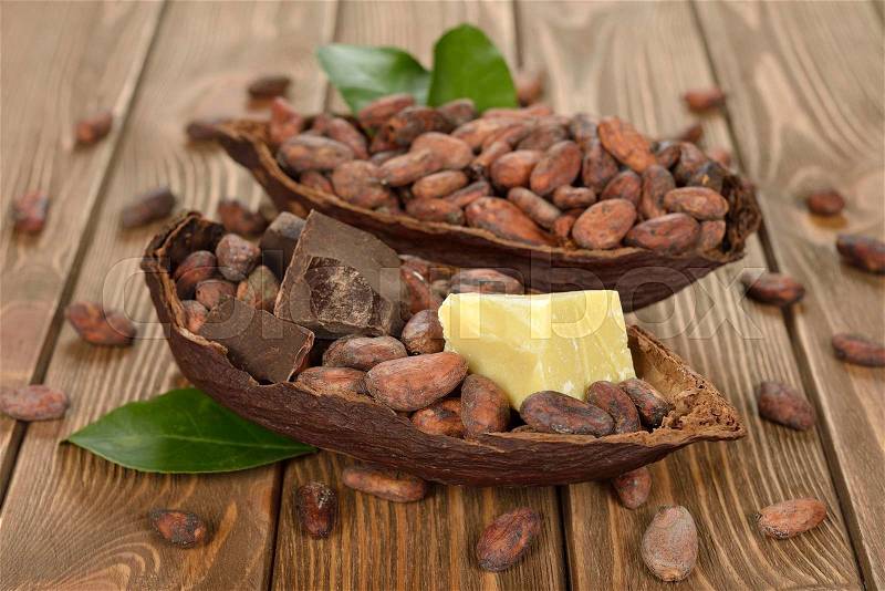 Cocoa beans, cocoa butter and cocoa mass on brown background, stock photo