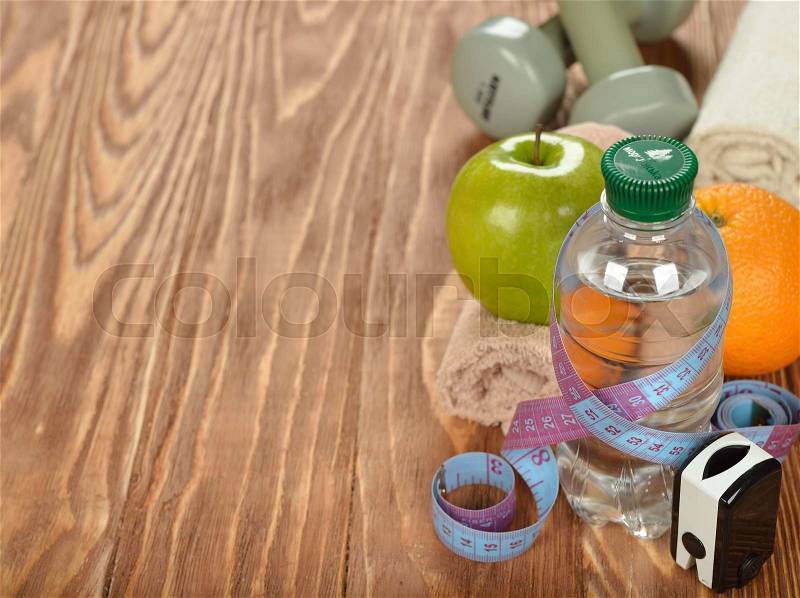 Bottle of water and measuring tape on a brown background, stock photo