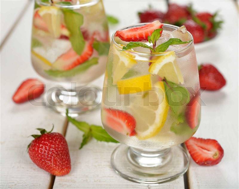 Cold drink with strawberries, lemon and mint on a white background, stock photo