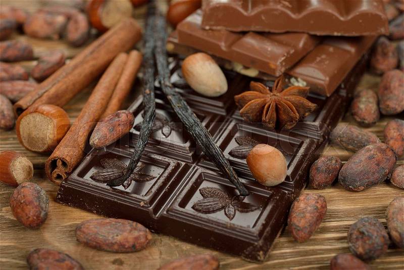 Chocolate, cocoa beans and spices on brown background, stock photo