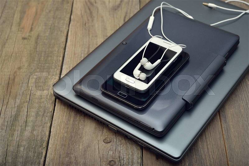 Laptop, tablet and mobile phone on a wooden background, stock photo