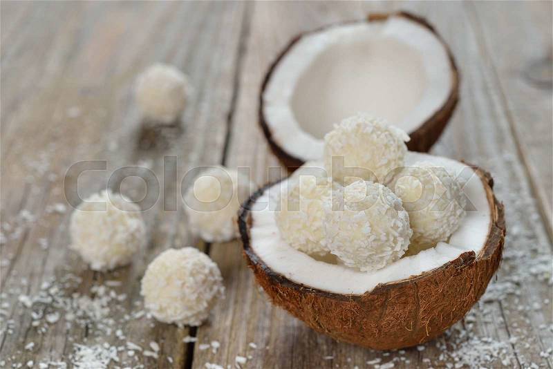 Coconut and coconut candies on a wooden background, stock photo