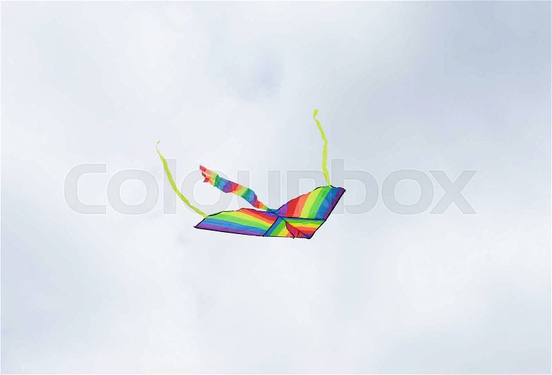 Flying kite in the air against the grey sky, stock photo